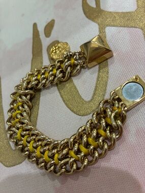 Bracelet gold tone links with yellow strands woven through to magnetic clasp